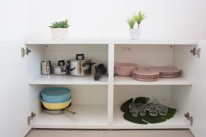 a white pantry with dishes and pots and pans at Cocor Suites & Design in Naples