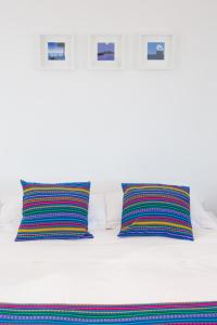 a white bed with two colorful pillows on it at Cocor Suites & Design in Naples