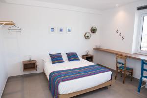 a white bedroom with a bed and a desk at Cocor Suites & Design in Naples