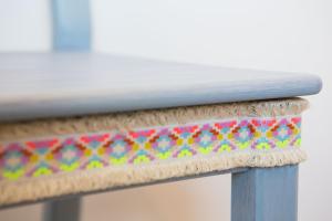 a close up of a wooden bench with a colorful seat at Cocor Suites & Design in Naples
