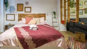 a bedroom with a large bed with a red blanket at Romea Suites in Murcia