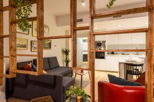 a living room with a couch and a kitchen at Romea Suites in Murcia