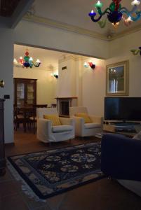 a living room with white couches and a flat screen tv at Appartamento Via Mazzini 16 in Perugia