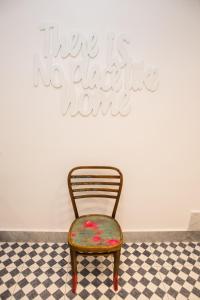 a chair in front of a wall with a sign at Cocor Suites & Design in Naples