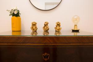 a table with three gold figurines on top of it at Cocor Suites & Design in Naples