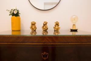 una tavola con tre statuine dorate sopra di Cocor Suites & Design a Napoli