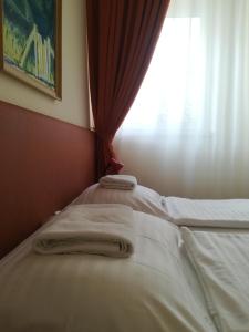 una cama con dos toallas delante de una ventana en Áldos Panzió, en Farád