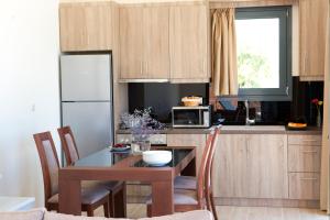 a kitchen with a table with chairs and a microwave at Nema Villa in Meganisi