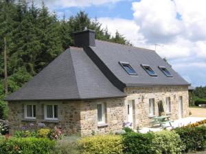 a stone house with a gambrel roof at Tasteful holiday home in Plouvara with garden in Saint-Donan