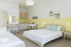 a bedroom with two beds and a kitchen at Theodora Rooms in Poros