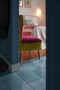 a room with a bed and a chair and a mirror at B&B Attico Partenopeo in Naples
