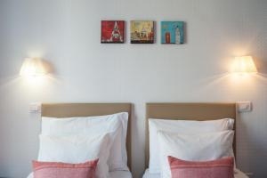 a bedroom with two pillows and two lights on the wall at B&B Attico Partenopeo in Naples