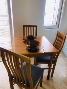 drewniany stół z 2 krzesłami oraz stół z płytami i okularami w obiekcie Apartment Igor w Budvie