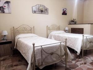 1 dormitorio con 2 camas con sábanas blancas y espejo en Umberto I - Affitti brevi, en Favara