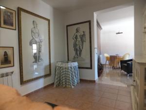 里奧帕爾的住宿－Puerta del Arco，客厅配有墙上的图片和桌子