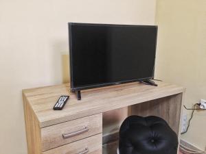 TV en un soporte de madera con mando a distancia en Umberto I - Affitti brevi, en Favara