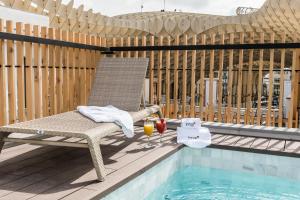 a chair sitting on a deck next to a swimming pool at Intelier Casa de Indias in Seville