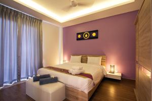 a bedroom with a large bed with purple walls at The Inspiration Residence in Rawai Beach