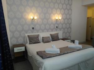 1 dormitorio con 1 cama con 2 almohadas en The Crown Hotel, en Stoke on Trent