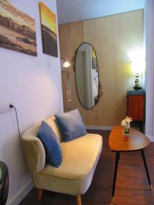 a living room with a couch and a mirror at Estudio con encanto en la playa (aptos.salinetas) in Telde