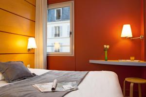 a hotel room with a bed with a window at Belambra City - Magendie in Paris