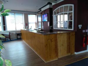 eine Bar in einem Zimmer mit Holzböden und Fenstern in der Unterkunft The Crown Hotel in Stoke on Trent