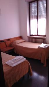 a room with two beds and a window at Casa per ferie Al Centro in Belluno