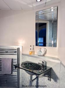 a bathroom with a sink and a mirror at Cwmbach Guest House in Neath