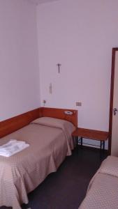 a room with two beds and a cross on the wall at Casa per ferie Al Centro in Belluno