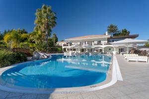 uma grande piscina em frente a uma casa em Martinhal Quinta Family Resort na Quinta do Lago