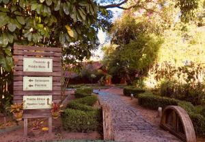 a garden with a sign next to a path at Vila Ventura Ecoresort in Viamão