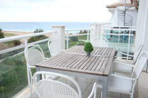 デニアにあるLes Portelles del mar 1ª línea Playaの木製テーブルと椅子、海を望むバルコニー