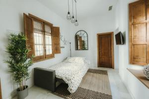a bedroom with a bed and a chair and a plant at LUXURY & NEW APARTMENT CORREDERA in Córdoba