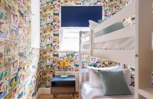 sypialnia dla dzieci z łóżkiem piętrowym i tapetą z kreskówki w obiekcie The Kensington Palace Mews - Bright & Modern 6BDR House with Garage w Londynie
