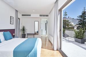 1 dormitorio con 1 cama grande y balcón en MONO Lofts, en Atenas