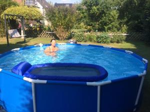 a woman is in a pool in a backyard at Düsseldorfer Privatzimmer in Düsseldorf