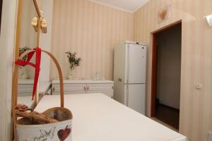 eine Küche mit einem weißen Kühlschrank und einem Tisch in der Unterkunft Апартаменты возле Вокзала, Центр in Dnipro