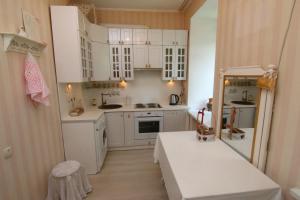 a small kitchen with white cabinets and a table at Апартаменты возле Вокзала, Центр in Dnipro