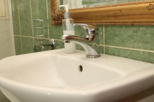a bathroom sink with a soap bottle on it at Апартаменты возле Вокзала, Центр in Dnipro +1 photo