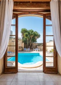 a view of a swimming pool through a window at Mood Farmhouse B&B in Għarb