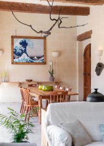een eetkamer met een houten tafel en stoelen bij Mood Farmhouse B&B in Għarb