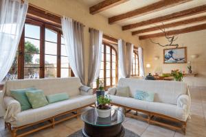 una sala de estar con 2 sofás blancos y ventanas en Mood Farmhouse B&B, en Għarb