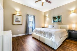 een slaapkamer met een groot wit bed en houten vloeren bij Modern 5BR Condo in NOLA in New Orleans