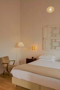 a bedroom with a bed and a chair and a lamp at Herdade do Ananás in Ponta Delgada