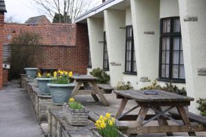 two picnic tables in front of a building with flowers at The Feathers in Pocklington