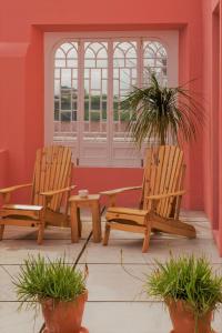 two wooden chairs sitting in a room with plants at Herdade do Ananás in Ponta Delgada