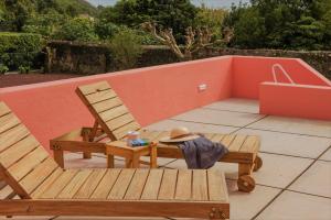 a patio with a bench and a hat and a chair at Herdade do Ananás in Ponta Delgada