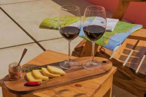 two glasses of wine on a cutting board with bananas at Herdade do Ananás in Ponta Delgada
