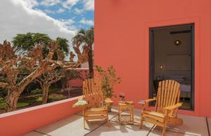 two chairs and a table on a balcony at Herdade do Ananás in Ponta Delgada