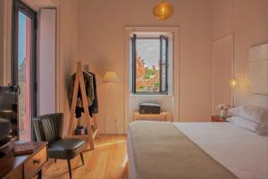 a bedroom with a bed and a chair and a window at Herdade do Ananás in Ponta Delgada